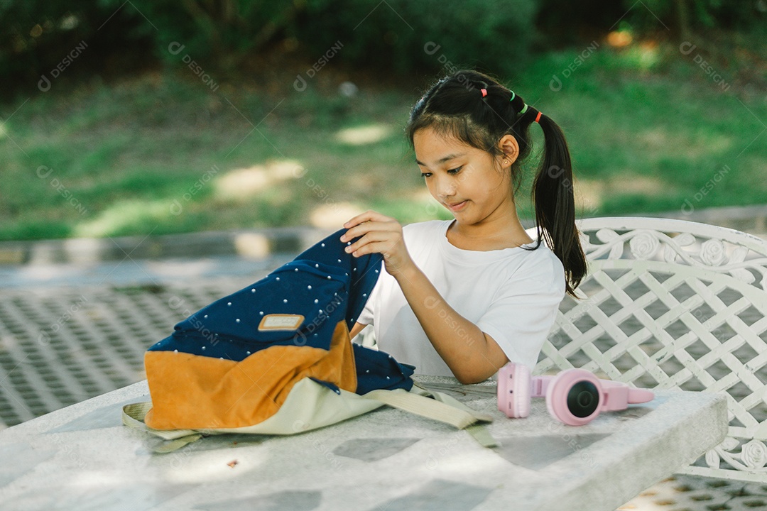 Garotinha sentada na mesa do quintal