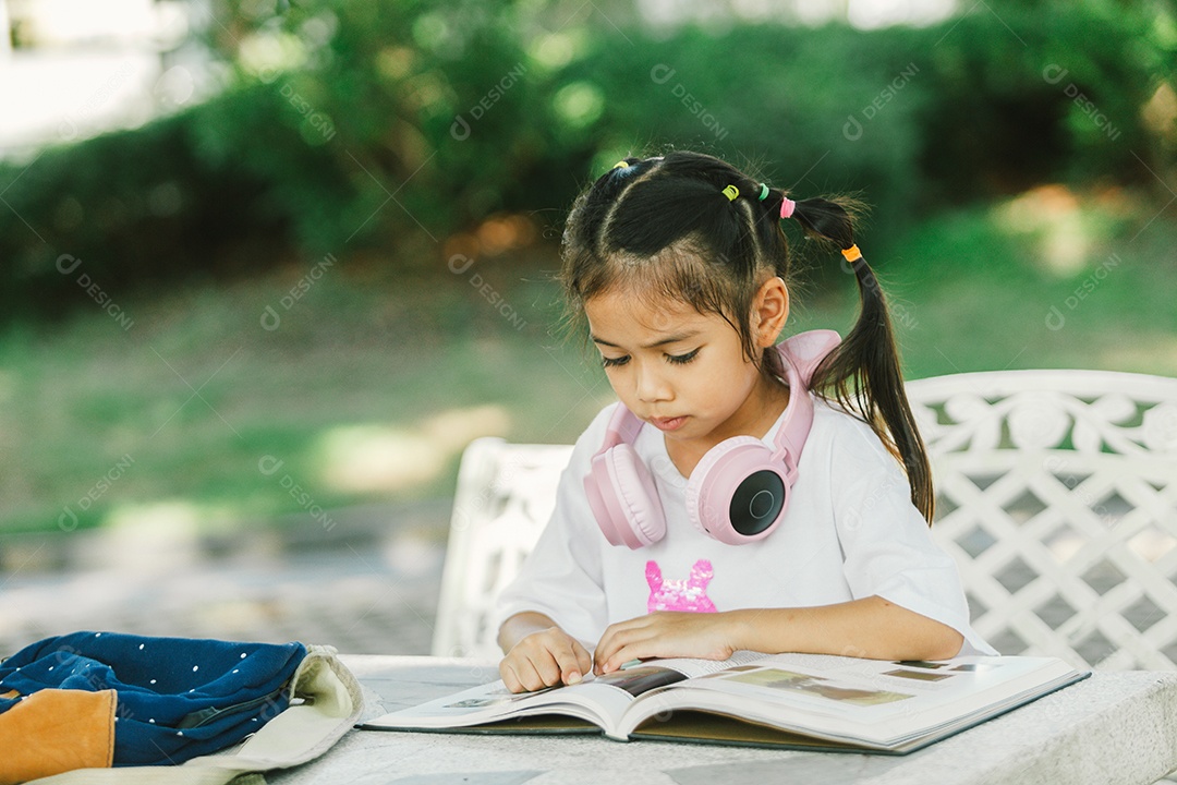 Garotinha sentada na mesa do quintal