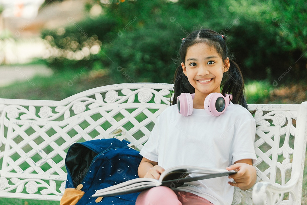 Linda garotinha sentada lendo livro