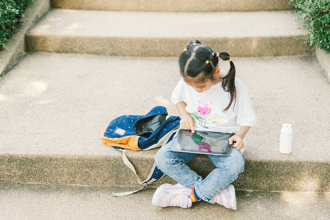 Menina sentada brincando no laptop