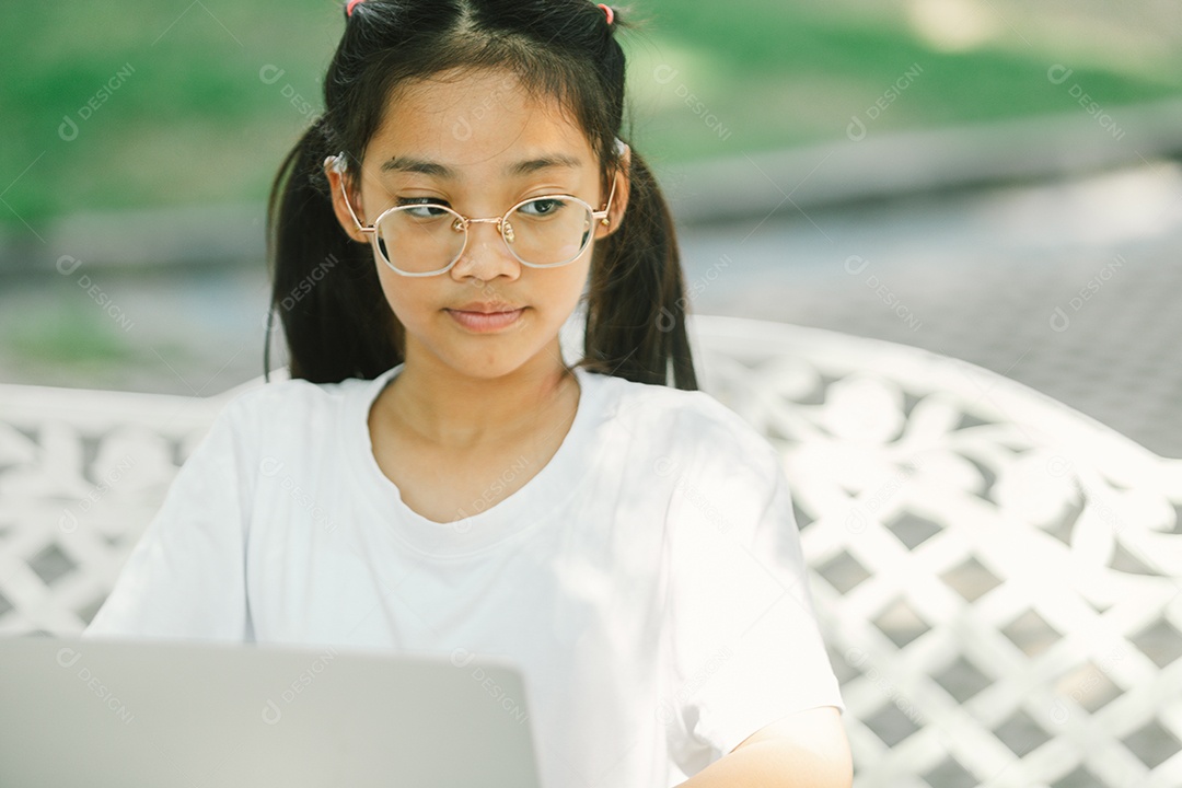 Menininha sentada usando laptop