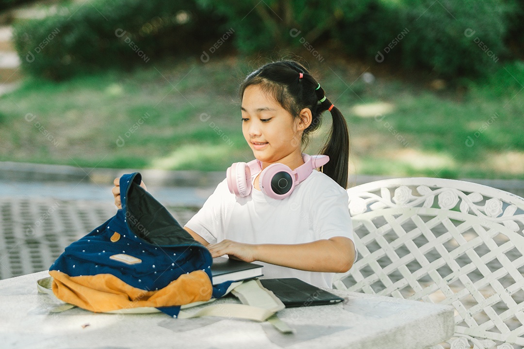 Menininha sentada na mesa do quintal