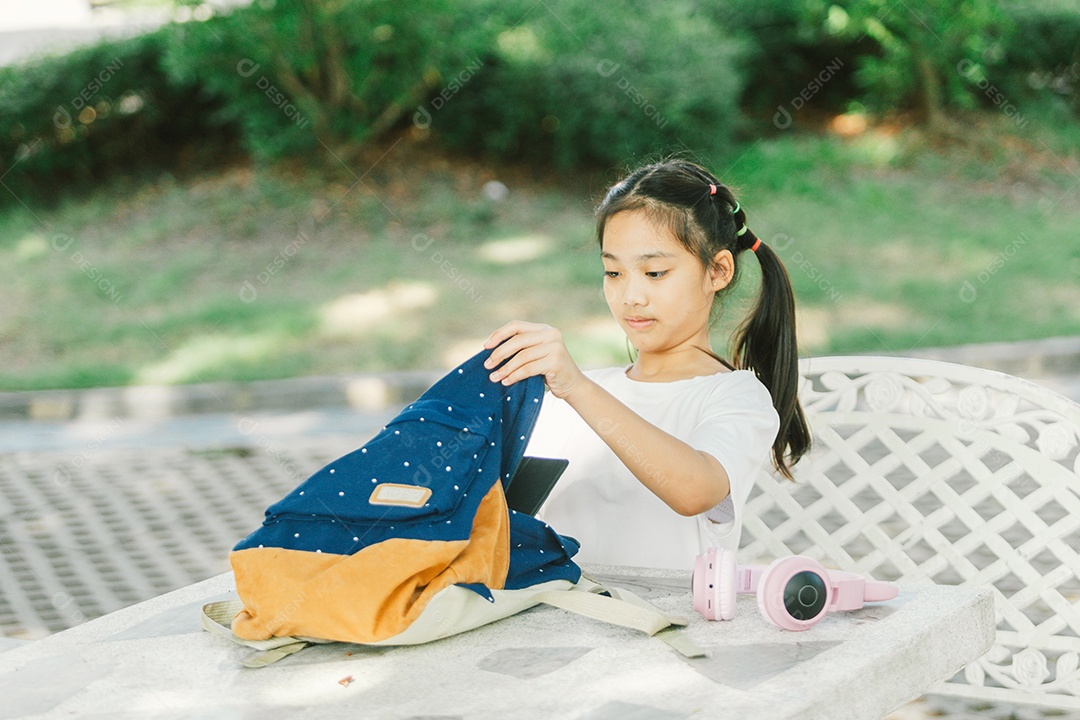 Menininha sentada na mesa do quintal