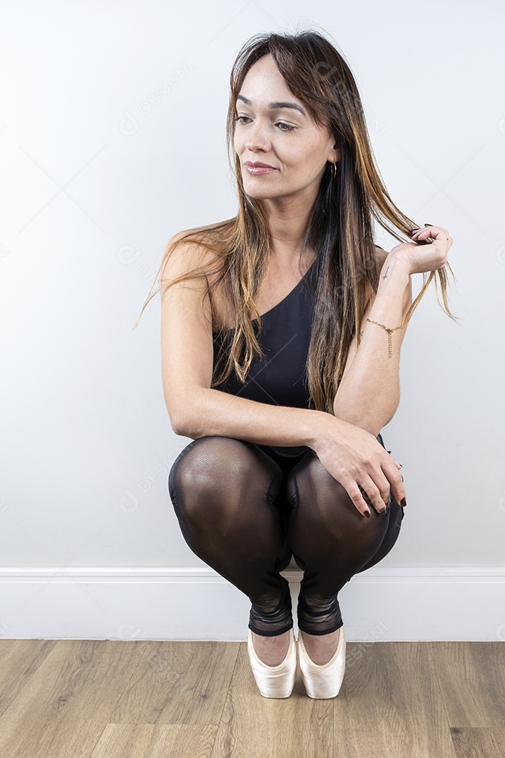 Bailarina brasileira de 37 anos posando em estúdio com sapatilhas