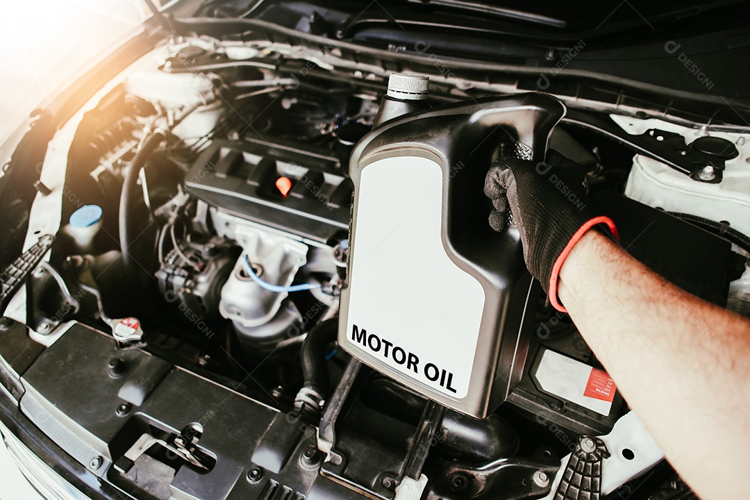 Mão de um mecânico segurando uma garrafa de óleo