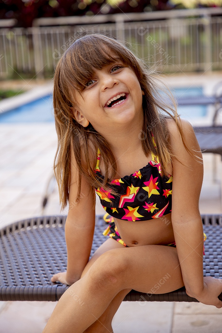 Linda garotinha feliz e sorridente usando biquini