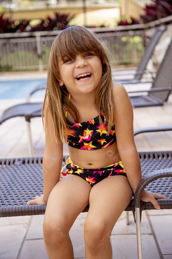 Linda garotinha feliz e sorridente usando biquini