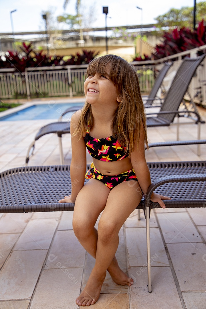 Linda garotinha feliz e sorridente usando biquini