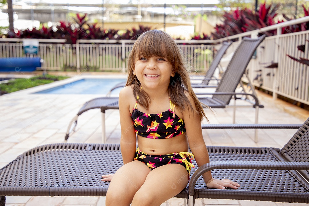 Linda garotinha feliz e sorridente usando biquini