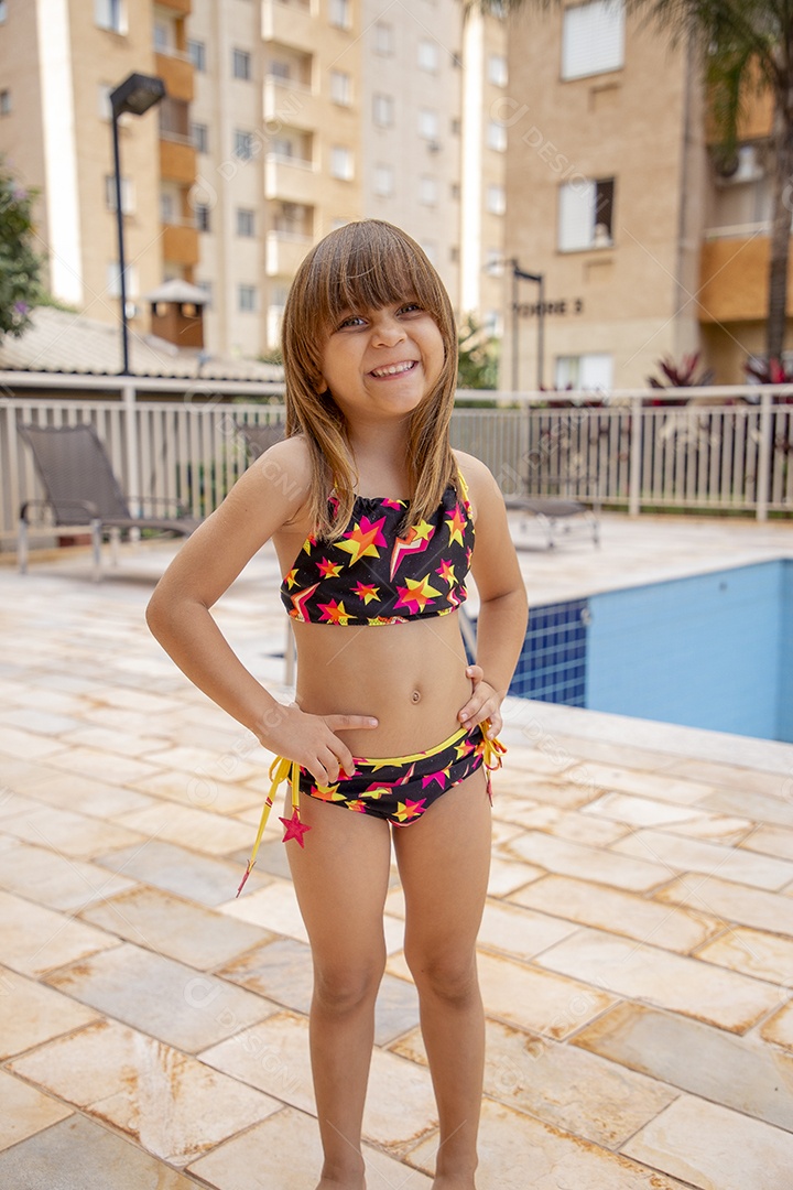 Linda garotinha feliz e sorridente usando biquini