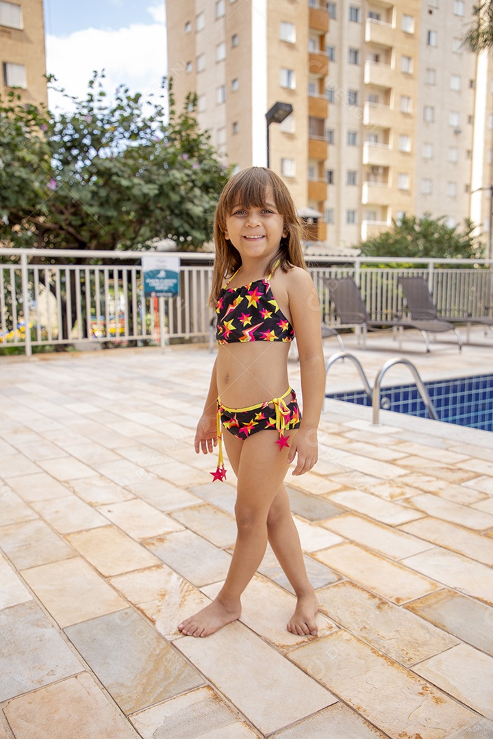 Linda garotinha feliz e sorridente usando biquini