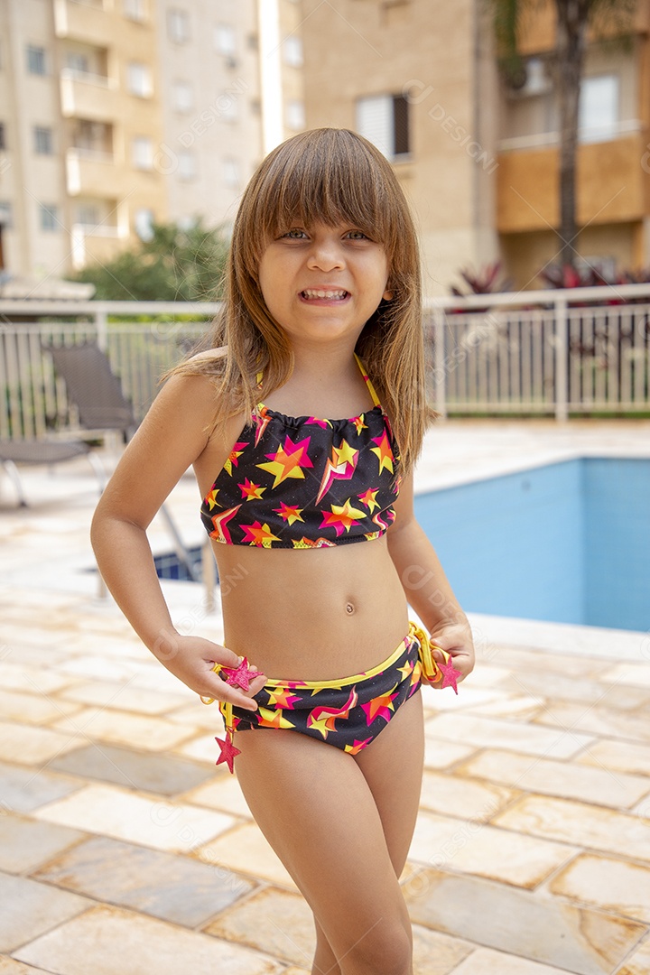 Linda garotinha feliz e sorridente usando biquini