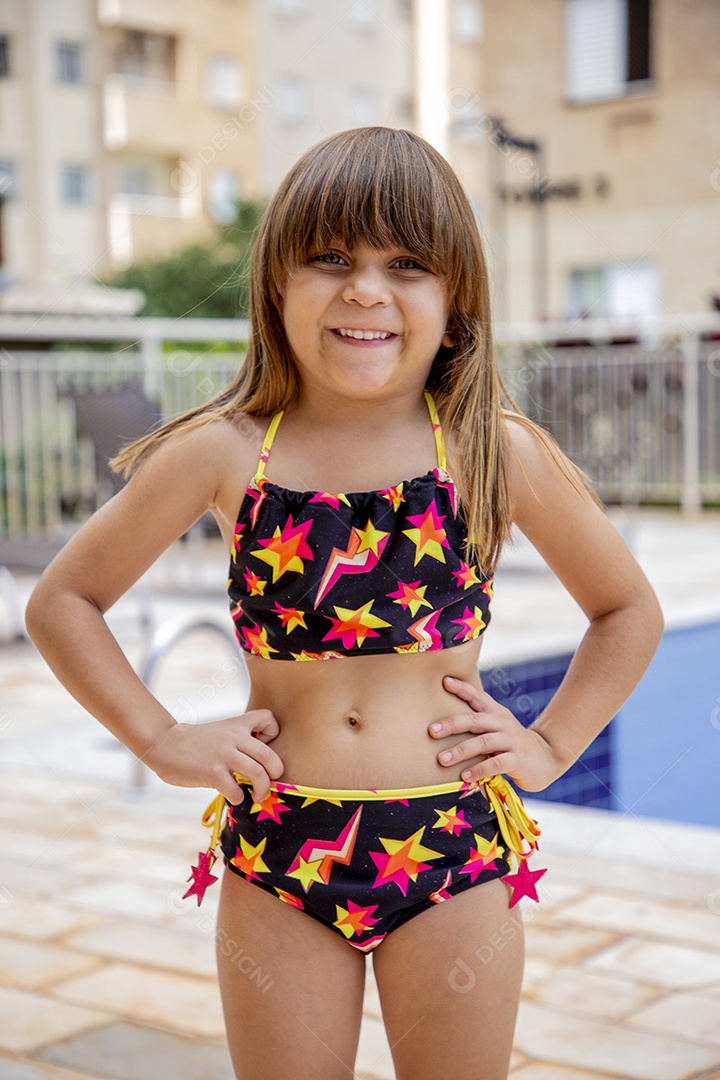 Linda garotinha feliz e sorridente usando biquini