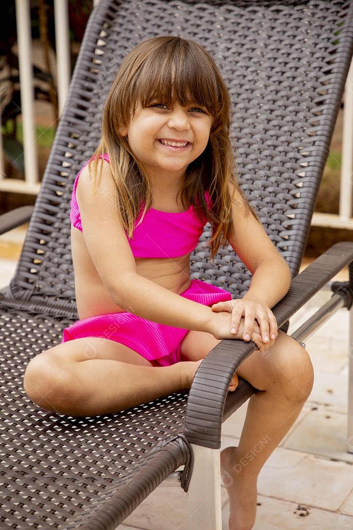 Linda garotinha feliz e sorridente usando biquini