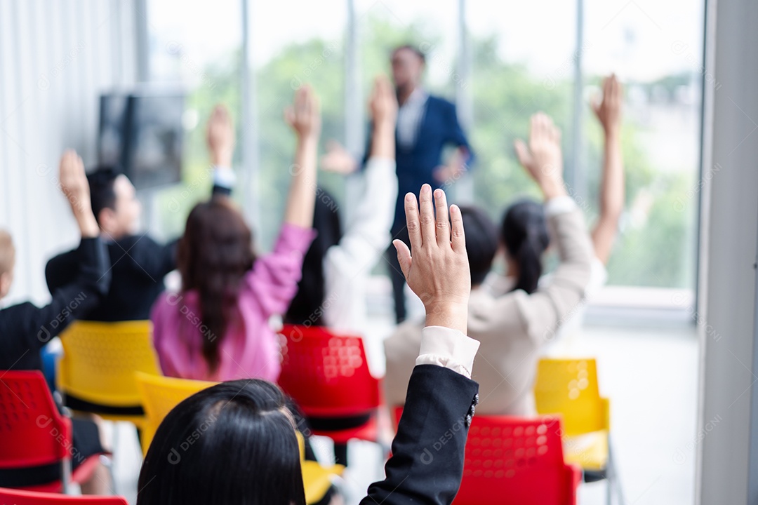 Pessoa de negócios levantando a mão durante o seminário.