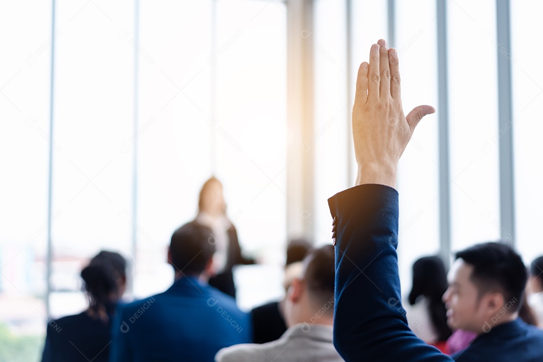Pessoa de negócios levantando a mão durante o seminário.