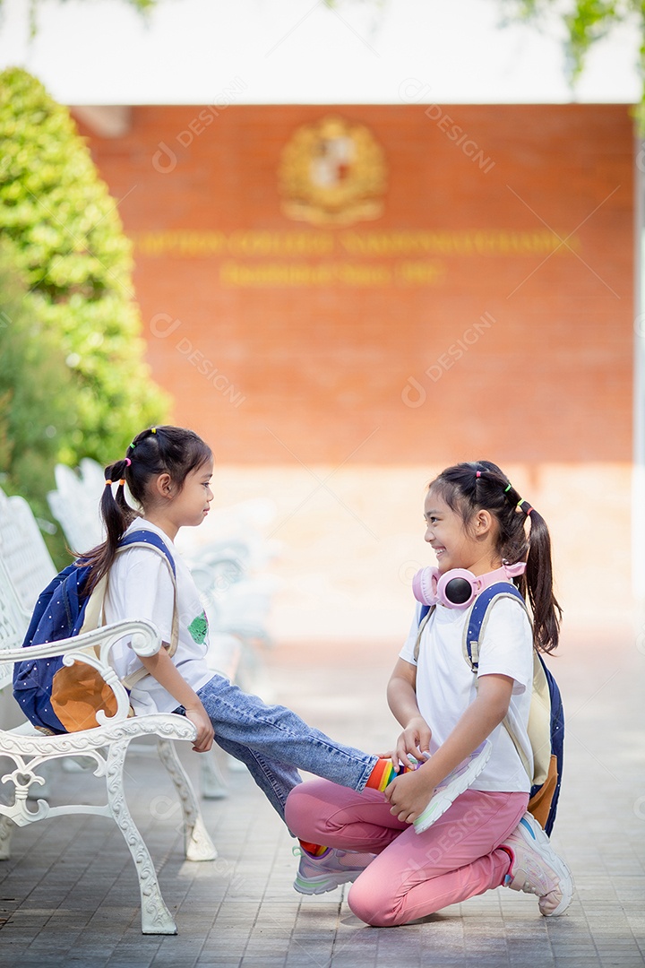 De volta à escola. Menina asiática lendo um livro. Alunos do ensino fundamental depois das aulas aprendendo lição de casa.
