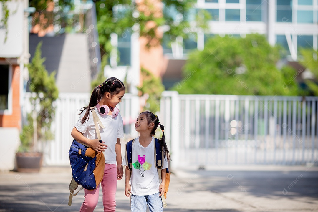 De volta à escola. Menina asiática lendo um livro. Alunos do ensino fundamental depois das aulas aprendendo lição de casa.