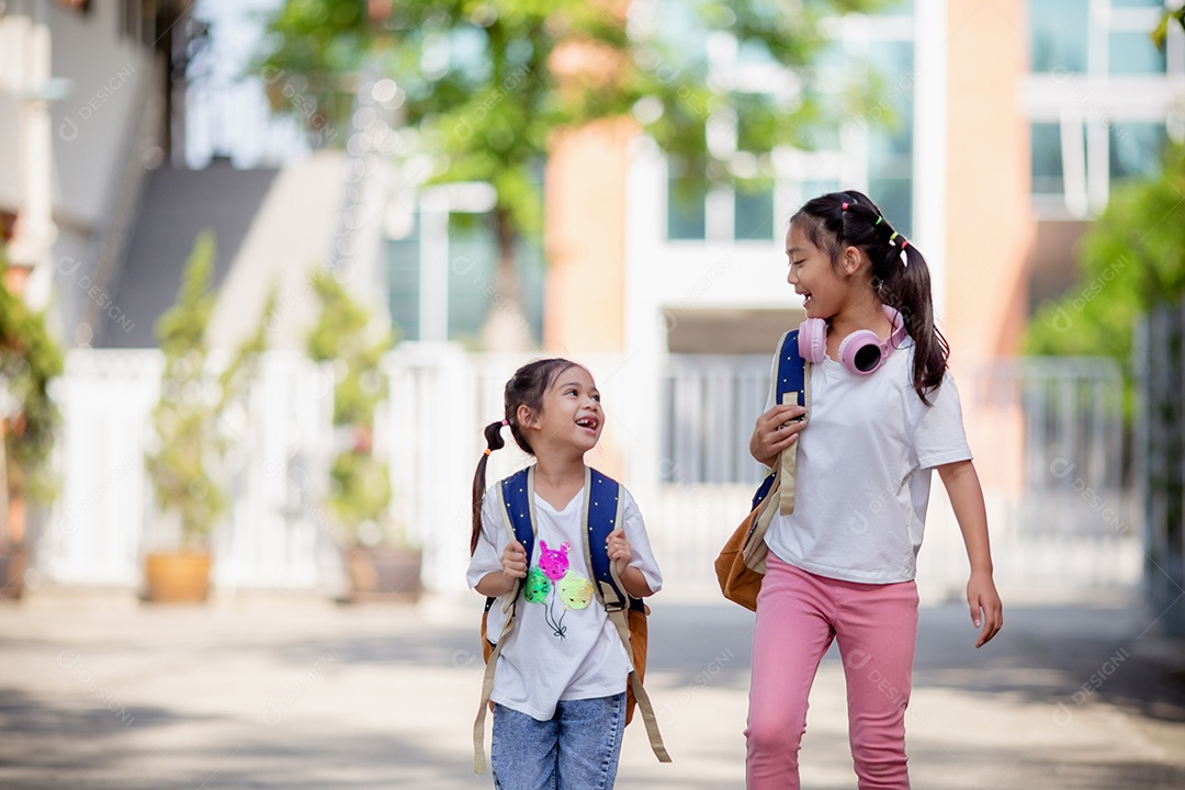 De volta à escola. Menina asiática lendo um livro. Alunos do ensino fundamental depois das aulas aprendendo lição de casa.