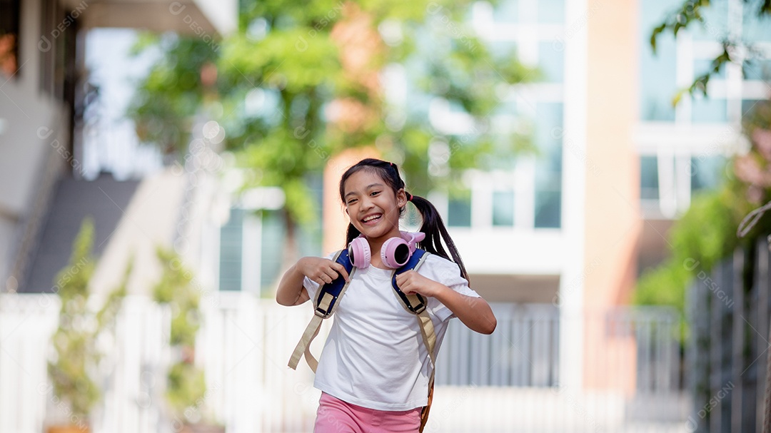 De volta à escola. Menina asiática lendo um livro. Alunos do ensino fundamental depois das aulas aprendendo lição de casa.