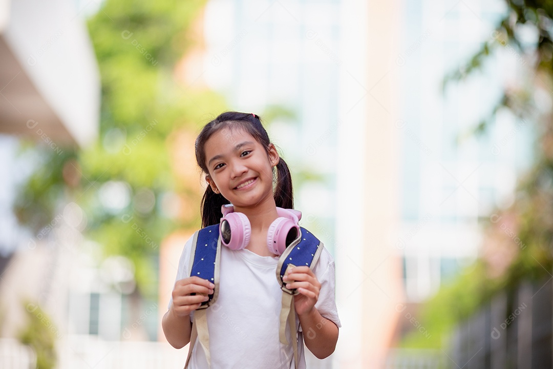 De volta à escola. Menina asiática lendo um livro. Alunos do ensino fundamental depois das aulas aprendendo lição de casa.