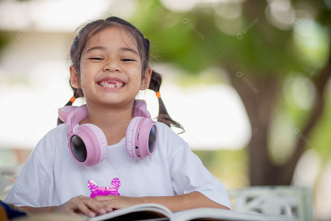 De volta à escola. Menina asiática lendo um livro. Alunos do ensino fundamental depois das aulas aprendendo lição de casa.