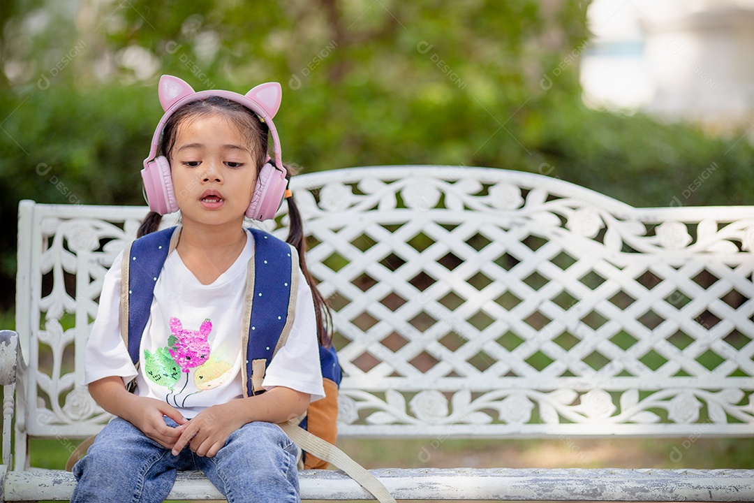 De volta à escola. Menina asiática lendo um livro. Alunos do ensino fundamental depois das aulas aprendendo lição de casa.