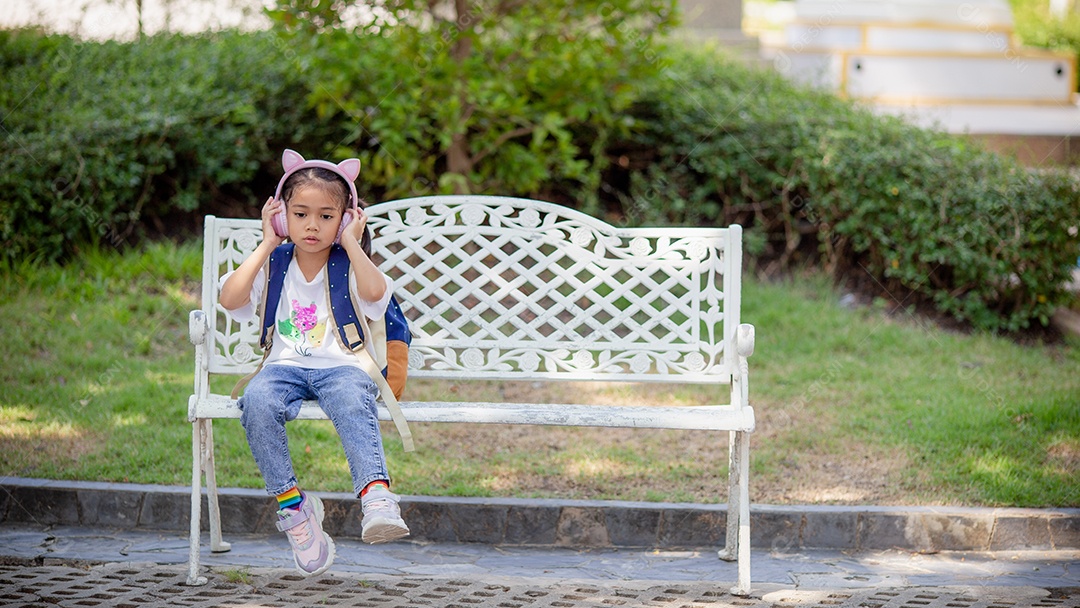 De volta à escola. Menina asiática lendo um livro. Alunos do ensino fundamental depois das aulas aprendendo lição de casa.