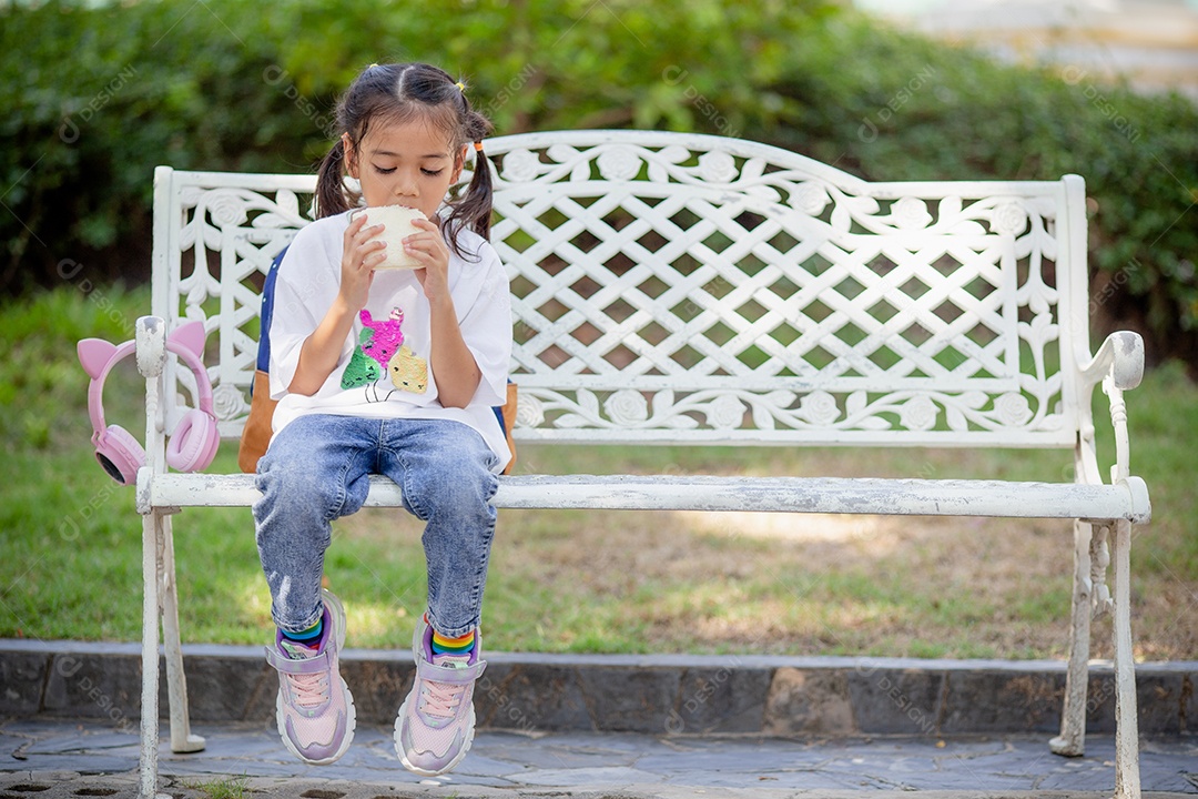 De volta à escola. Menina asiática lendo um livro. Alunos do ensino fundamental depois das aulas aprendendo lição de casa.