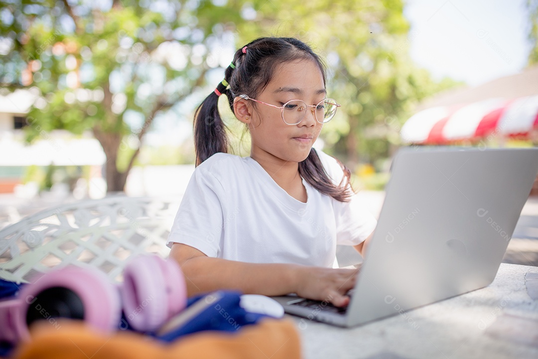 De volta à escola. Menina asiática lendo um livro. Alunos do ensino fundamental depois das aulas aprendendo lição de casa.