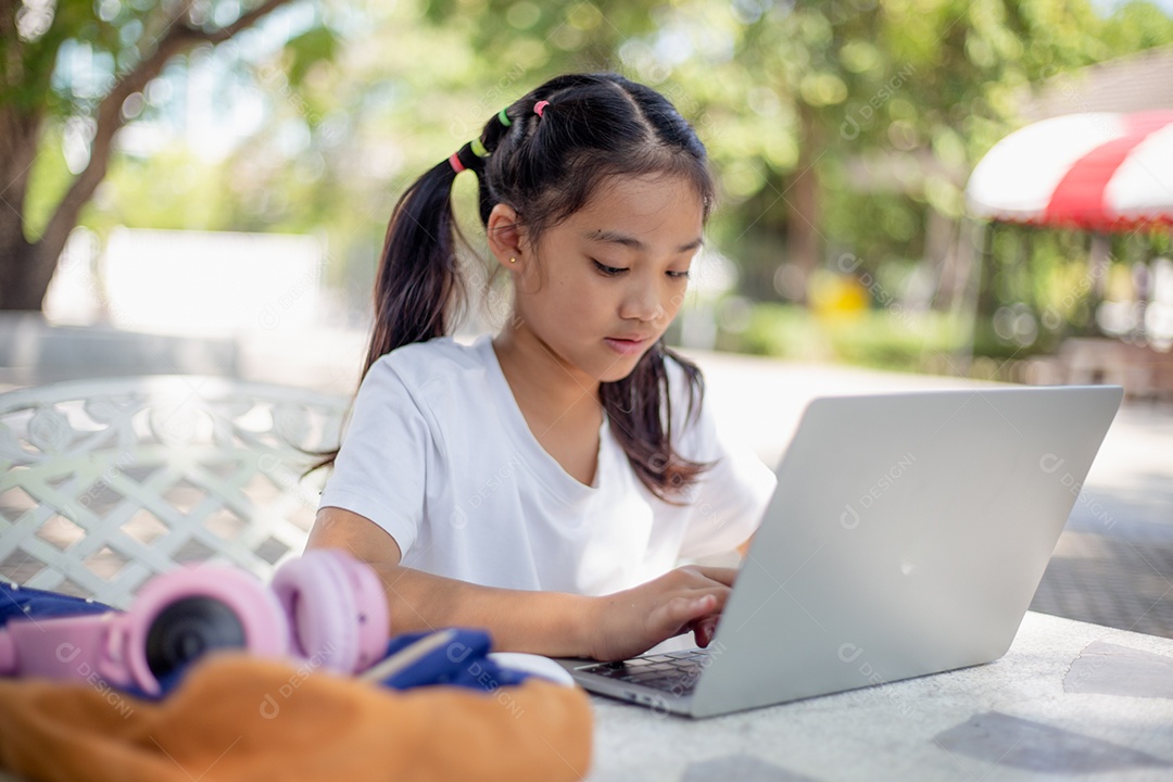 De volta à escola. Menina asiática lendo um livro. Alunos do ensino fundamental depois das aulas aprendendo lição de casa.