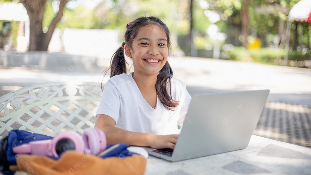 De volta à escola. Menina asiática lendo um livro. Alunos do ensino fundamental depois das aulas aprendendo lição de casa.