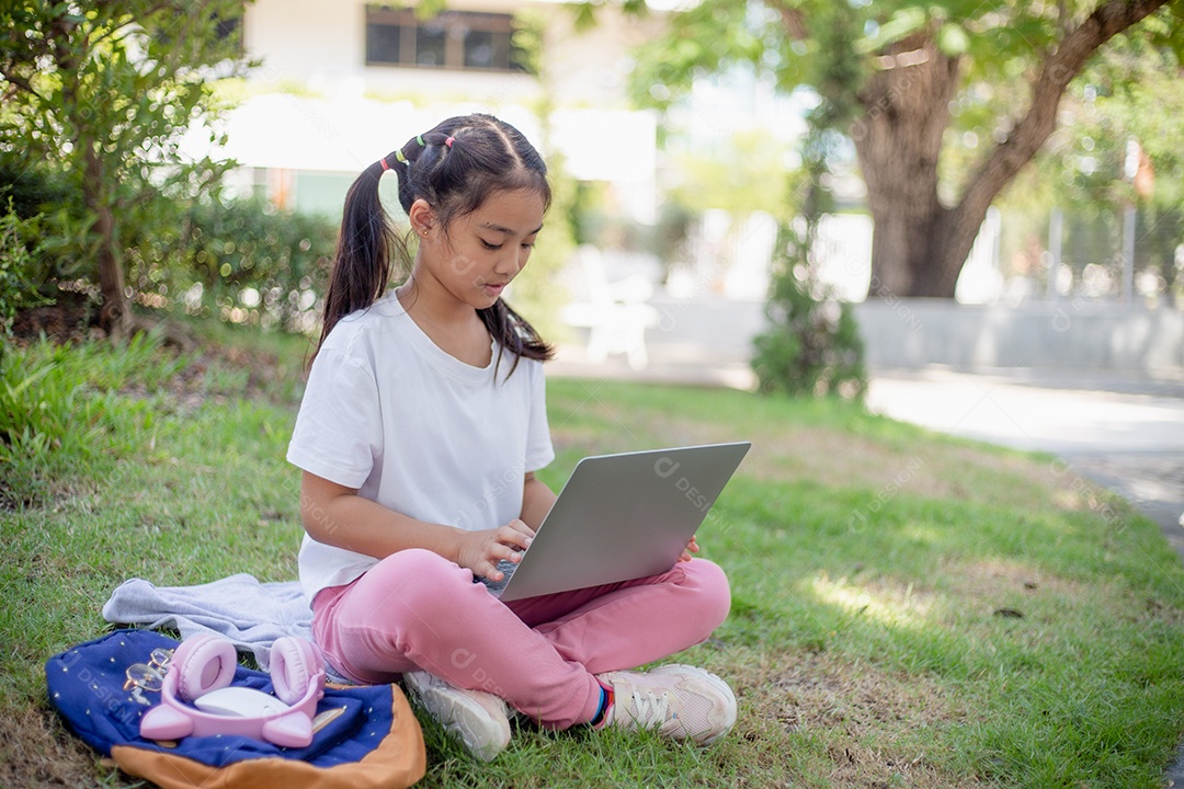 De volta à escola. Menina asiática lendo um livro. Alunos do ensino fundamental depois das aulas aprendendo lição de casa.