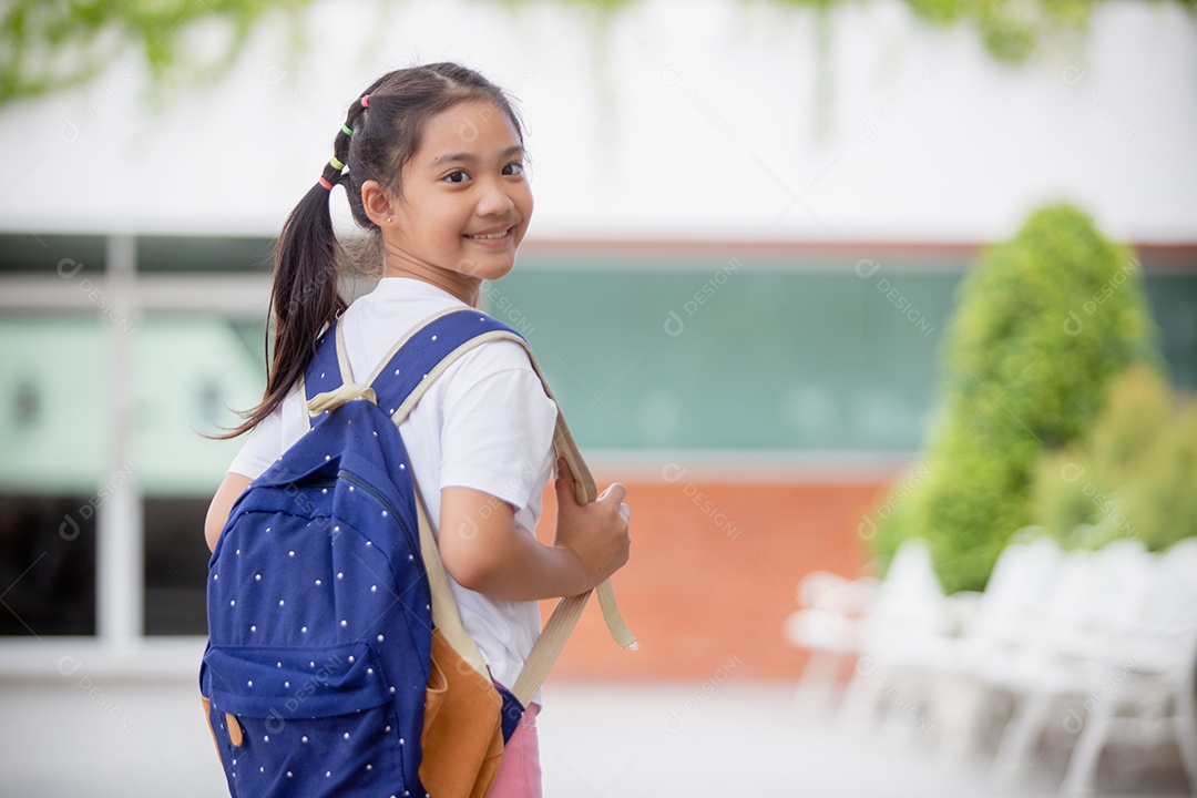 De volta à escola. Menina asiática lendo um livro. Alunos do ensino fundamental depois das aulas aprendendo lição de casa.