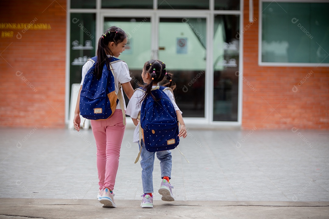 De volta à escola. Menina asiática lendo um livro. Alunos do ensino fundamental depois das aulas aprendendo lição de casa.