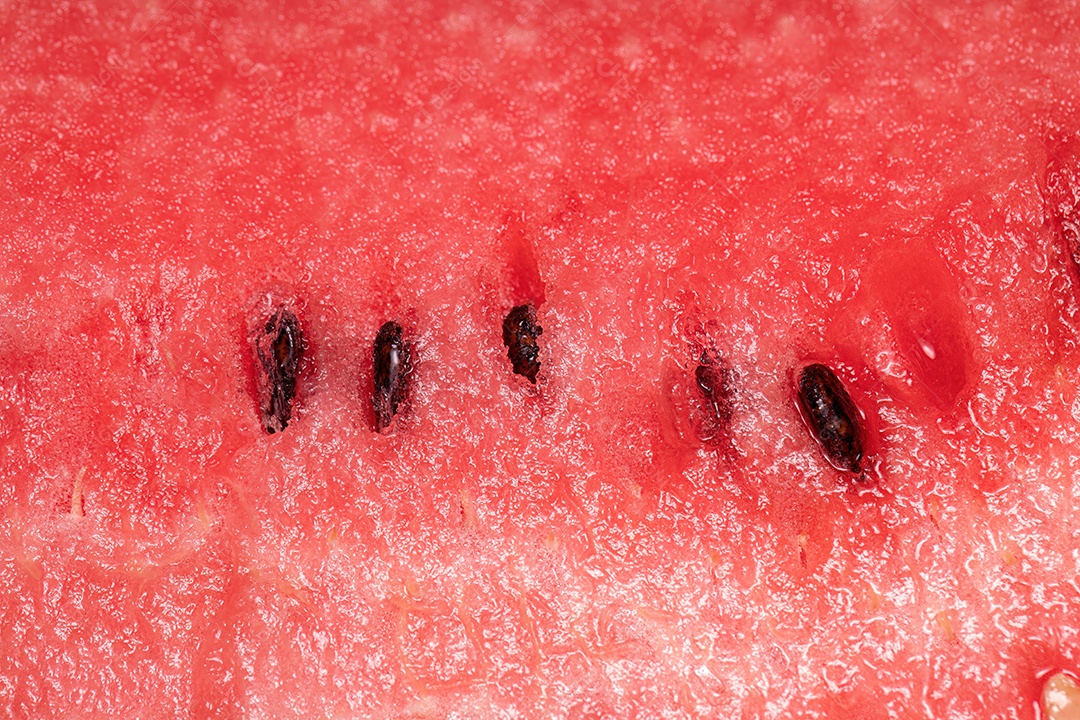fotografia macro de textura vermelha de uma melancia fatiada com sementes
