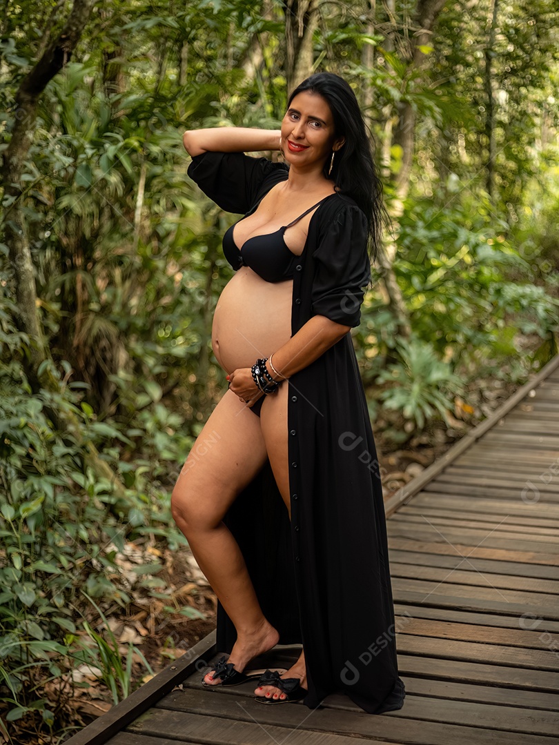 Mulher grávida posando em sessão de fotos feminina na natureza