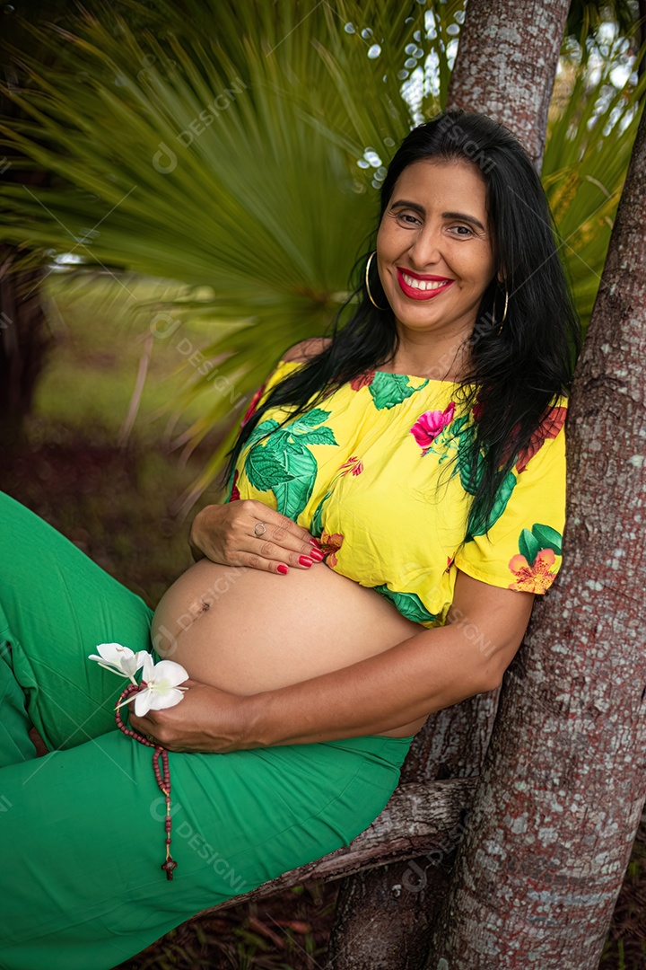 Mulher grávida posando em sessão de fotos feminina em um parque