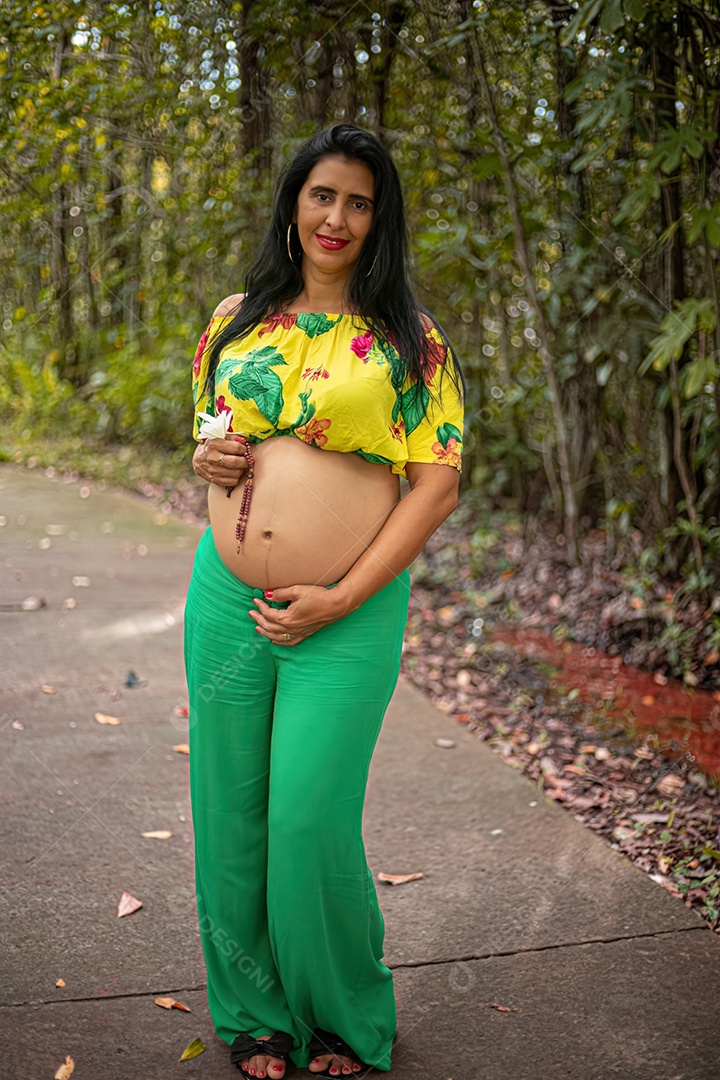 Mulher grávida posando em sessão de fotos feminina em um parque