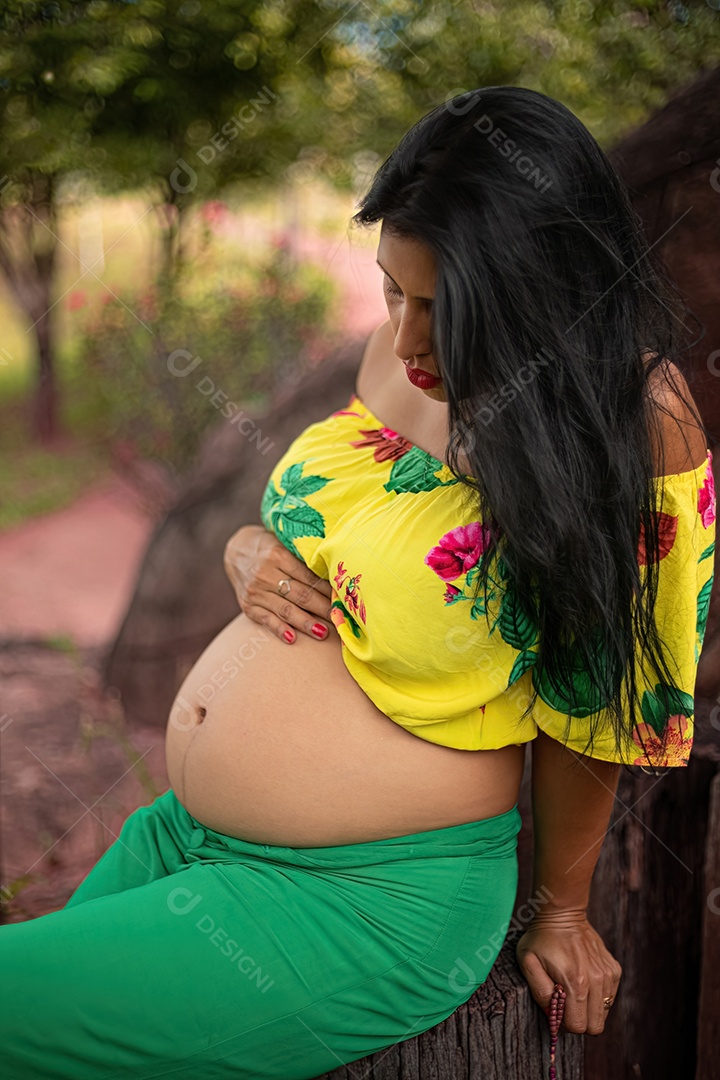 Mulher grávida posando em sessão de fotos feminina em um parque