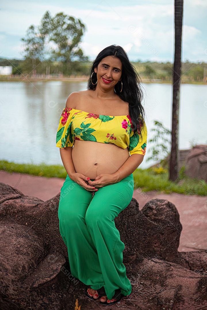 Mulher grávida posando em sessão de fotos feminina em um parque