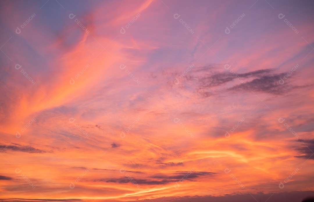 Lindas nuvens laranja gradientes e luz solar no céu azul perfeitas para o fundo