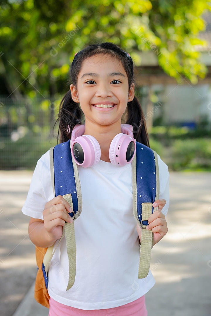 Criança menina asiática com uma mochila indo para a escola com diversão.