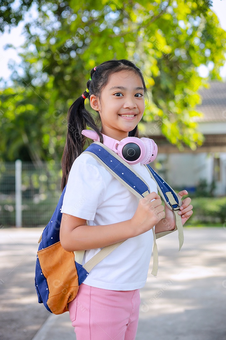 Criança menina asiática com uma mochila indo para a escola com diversão.