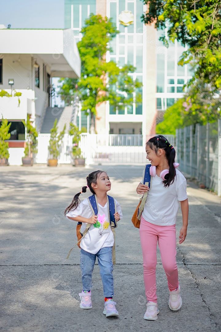 Criança menina asiática com uma mochila indo para a escola com diversão.