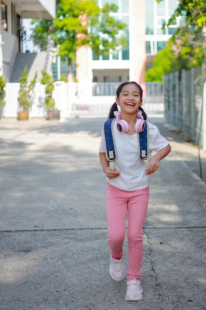 Criança menina asiática com uma mochila indo para a escola com diversão.