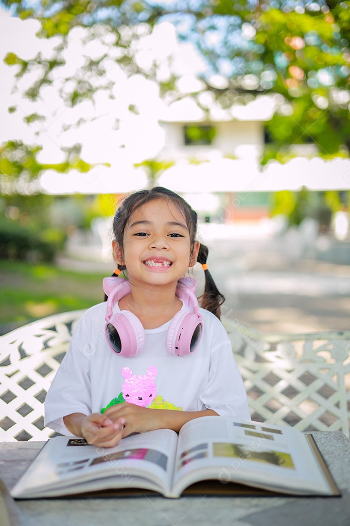 Menina asiática lendo um livro depois das aulas aprendendo lição de casa
