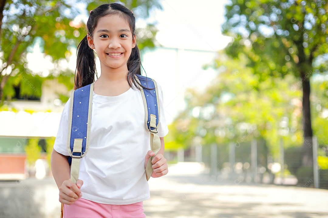 Criança menina asiática com uma mochila indo para a escola com diversão.