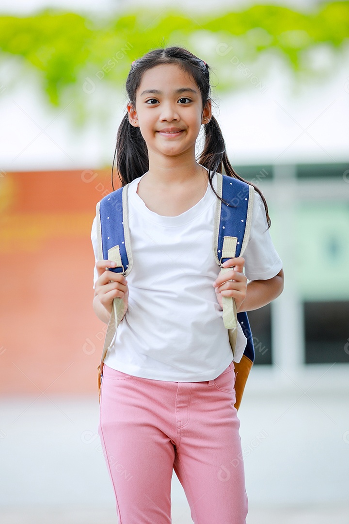 Criança menina asiática com uma mochila indo para a escola com diversão.