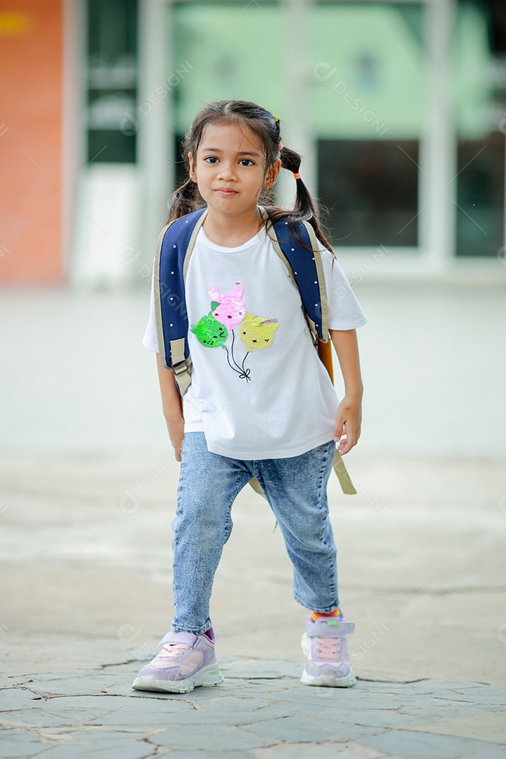 Criança menina asiática com uma mochila indo para a escola com diversão.